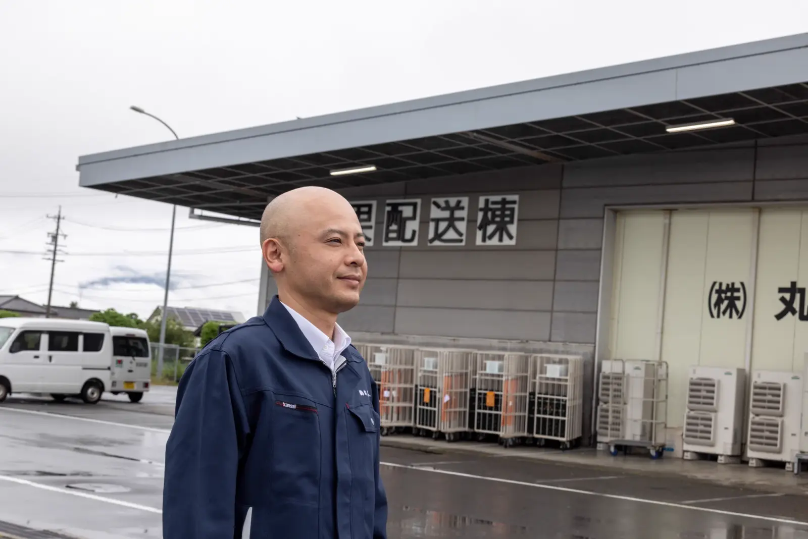 配送棟の前で遠くを見つめる代表取締役社長 中島康喜